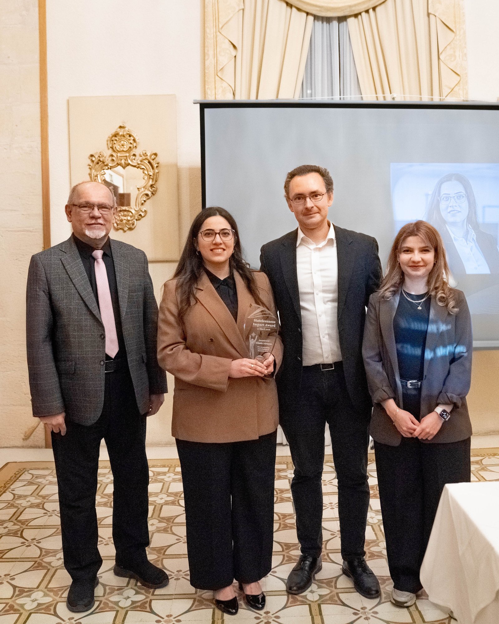 Ghada Alrayan holding the award with fellow ceremony participants