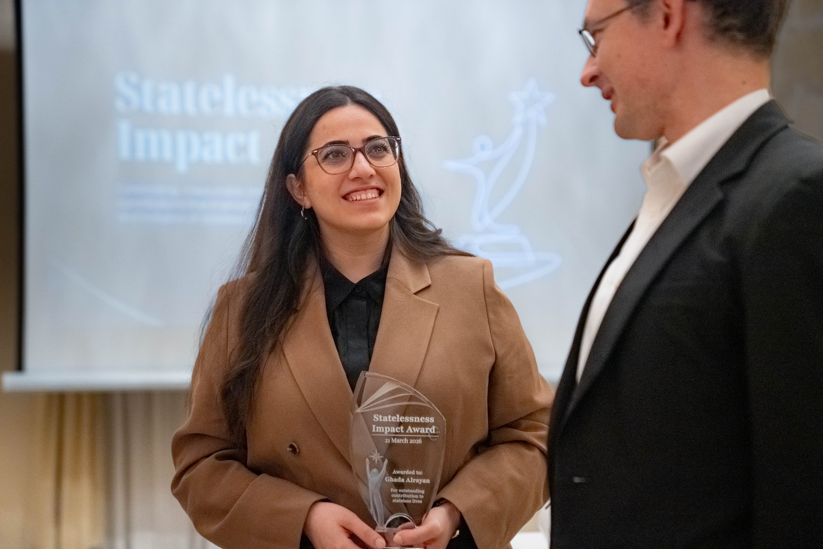 Ghada Alrayan holding the inaugural Statelessness Impact Award at the Malta ceremony